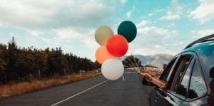 Driving car with celebration balloons